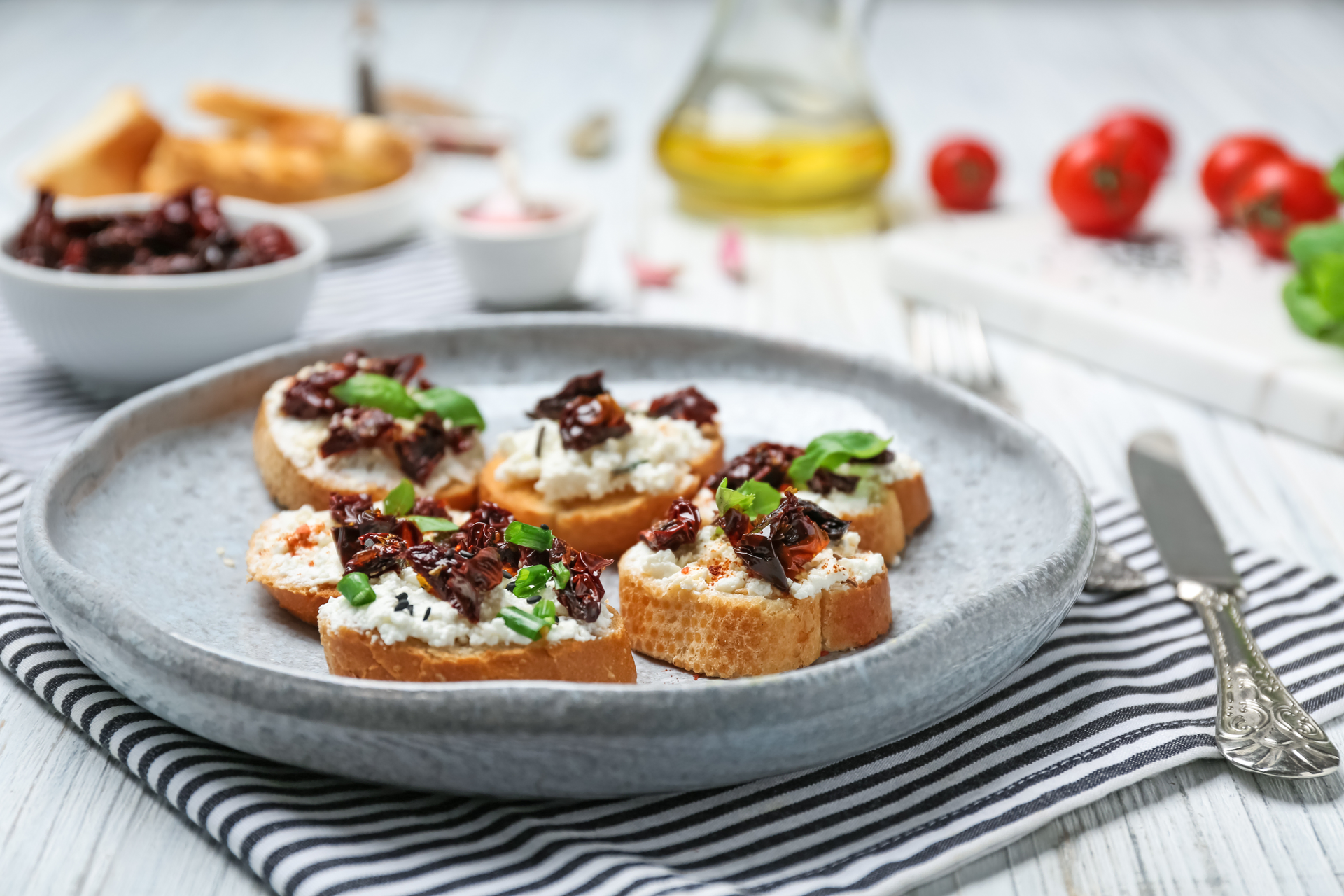 Overhead flat-lay of all ingredients for Tangy Greek Kalamata Olive Tapenade Crostini with Feta laid out on a kitchen surface.