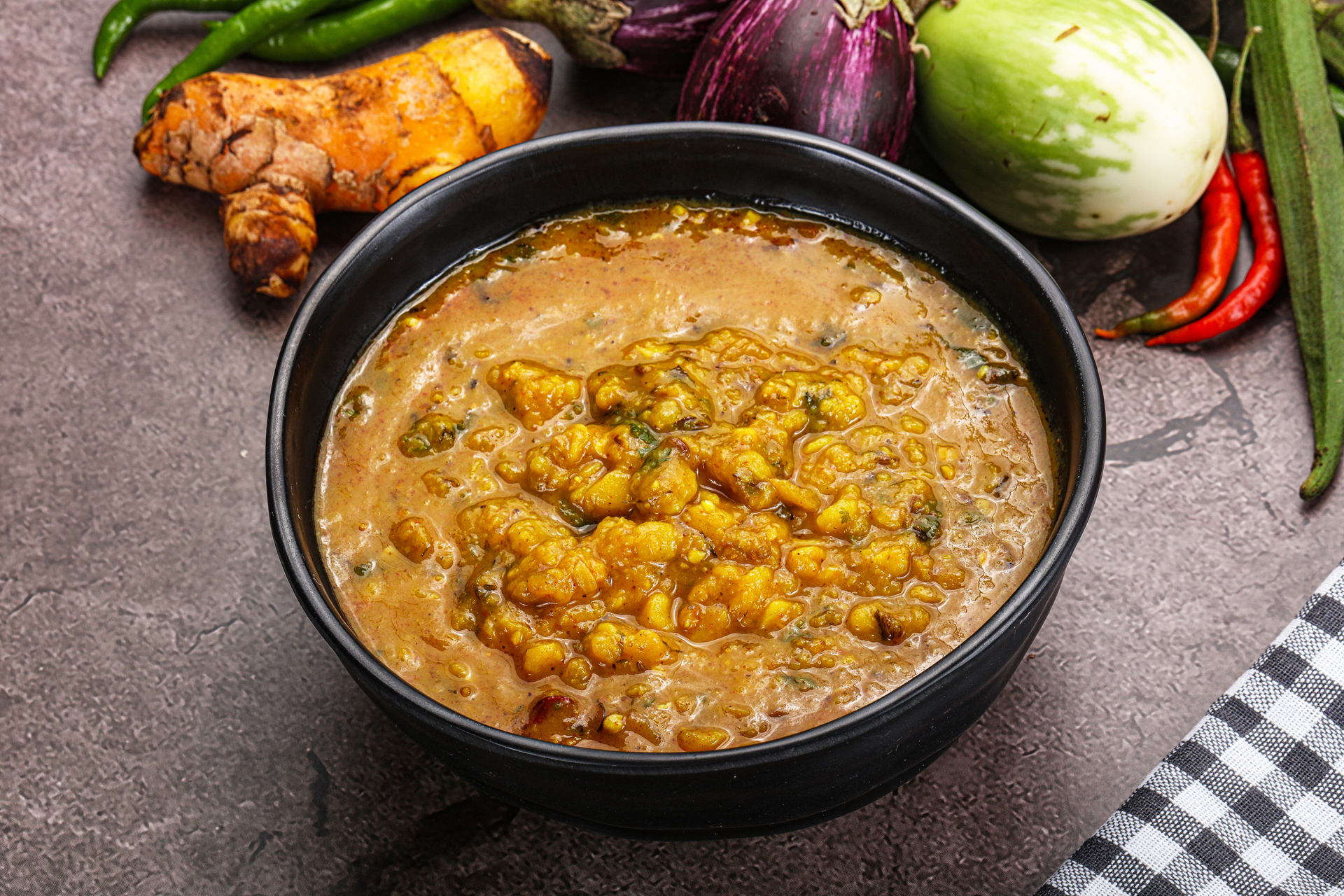 Overhead flat-lay of all ingredients for Tangy Indian Tamarind Koddel with Chana Dal laid out on a kitchen surface.