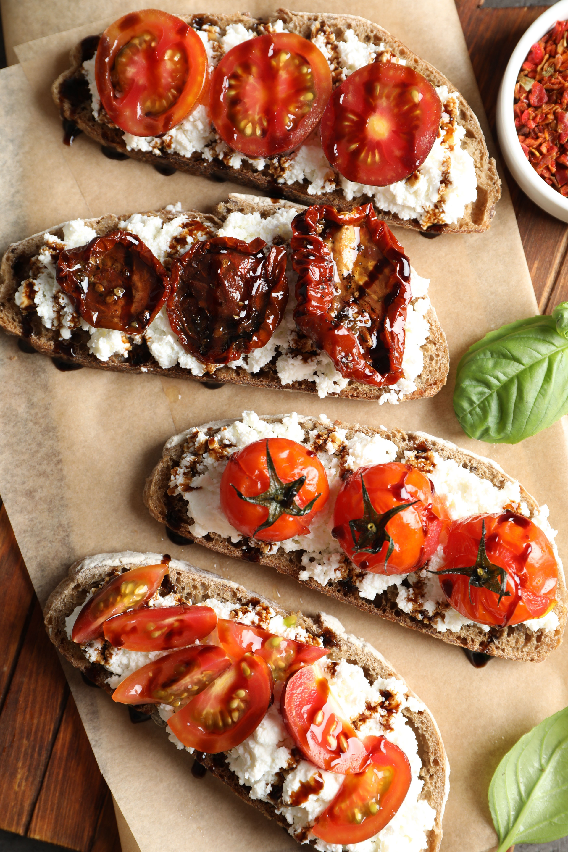Overhead flat-lay of all ingredients for Tangy Italian Bruschetta with Tomato Jam and Balsamic Reduction laid out on a kitchen surface.