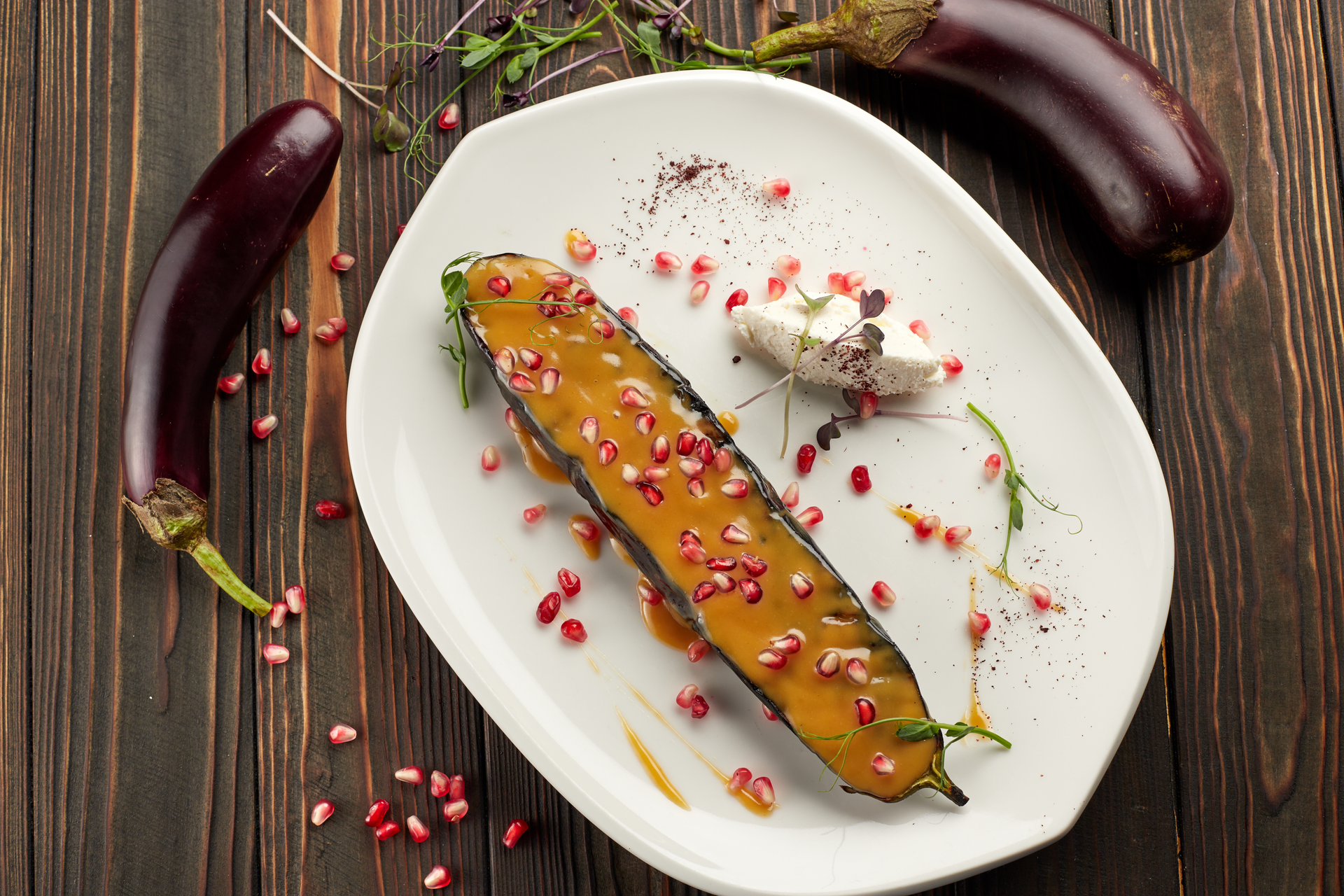 Overhead flat-lay of all ingredients for Tangy Lebanese Za'atar Baked Eggplant with Pomegranate Seeds laid out on a kitchen surface.