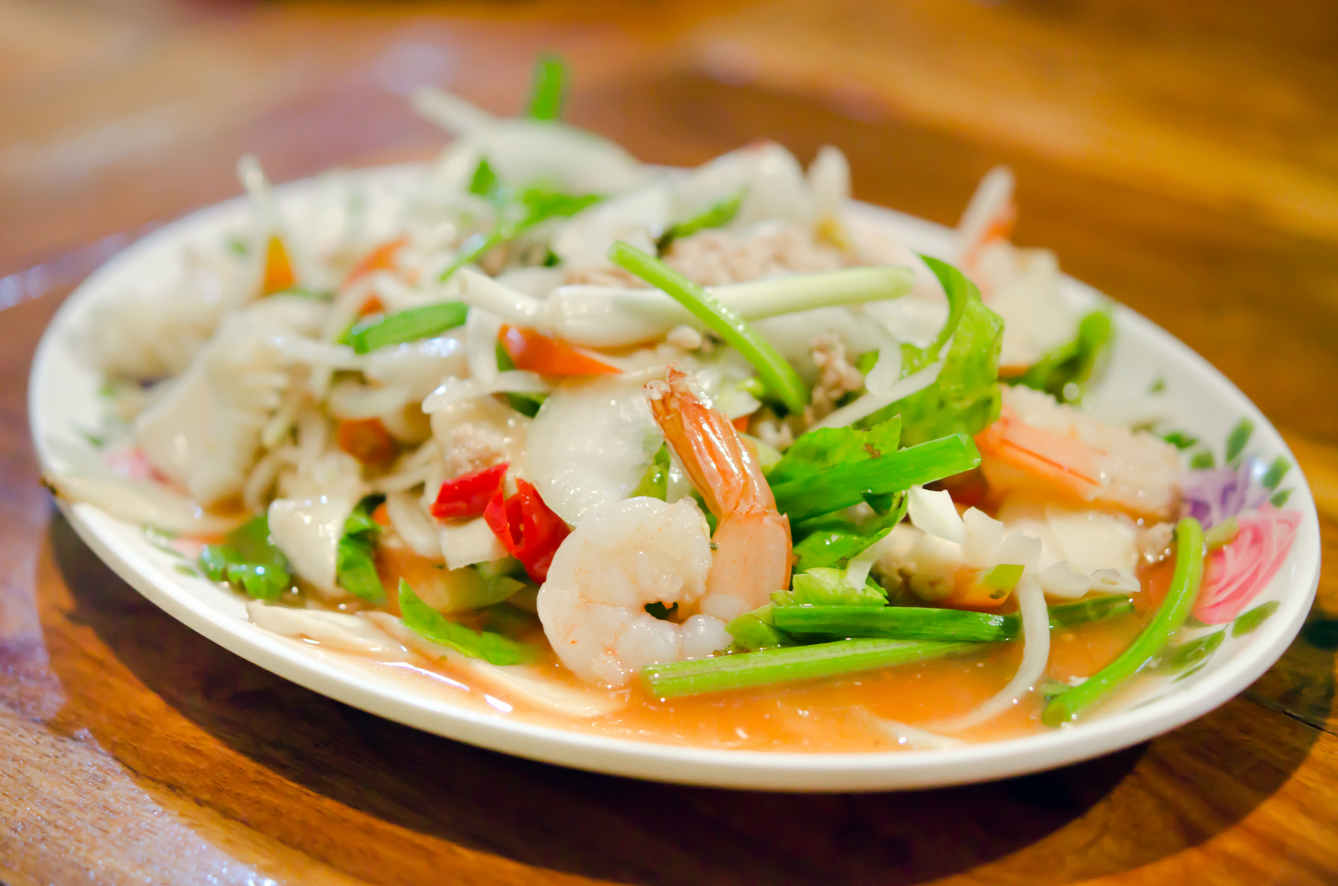 Overhead flat-lay of all ingredients for Tangy Thai Green Mango and Shrimp Salad with Chilis laid out on a kitchen surface.