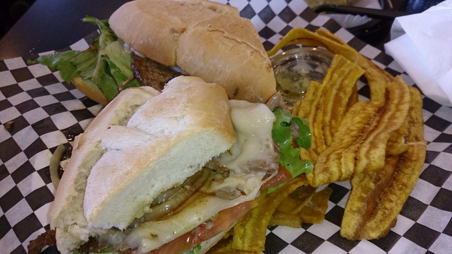 Overhead flat-lay of all ingredients for Tangy Venezuelan Pepito Sandwich with Spicy Mustard Relish laid out on a kitchen surface.
