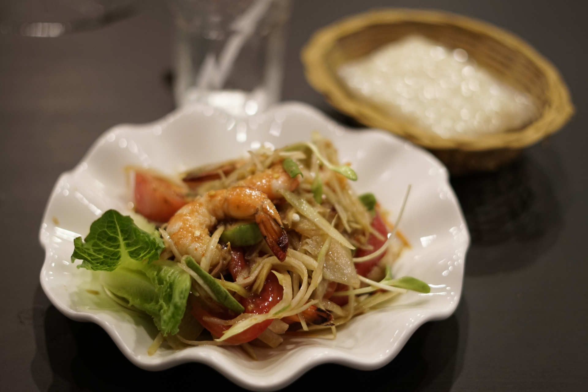 Overhead flat-lay of all ingredients for Tangy Vietnamese Green Mango Salad with Grilled Shrimp laid out on a kitchen surface.