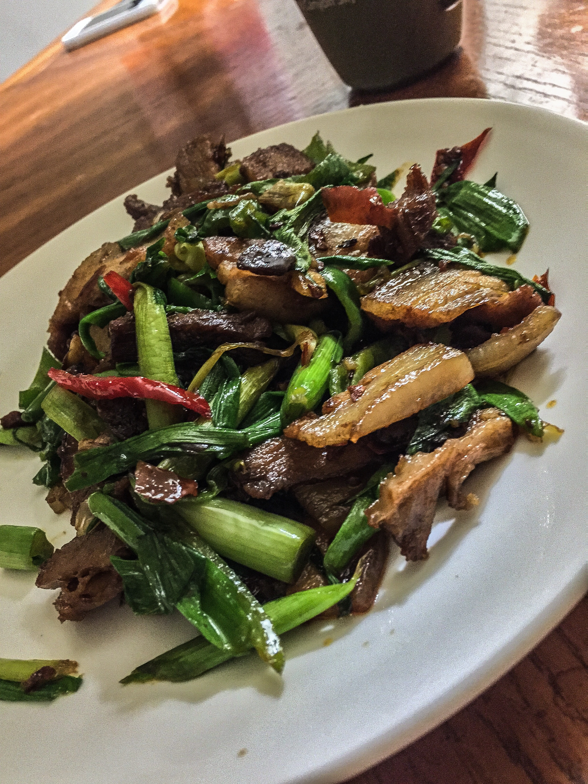 Overhead flat-lay of all ingredients for Tender Szechuan Peppercorn Beef Stir-Fry with Garlic Shoots laid out on a kitchen surface.