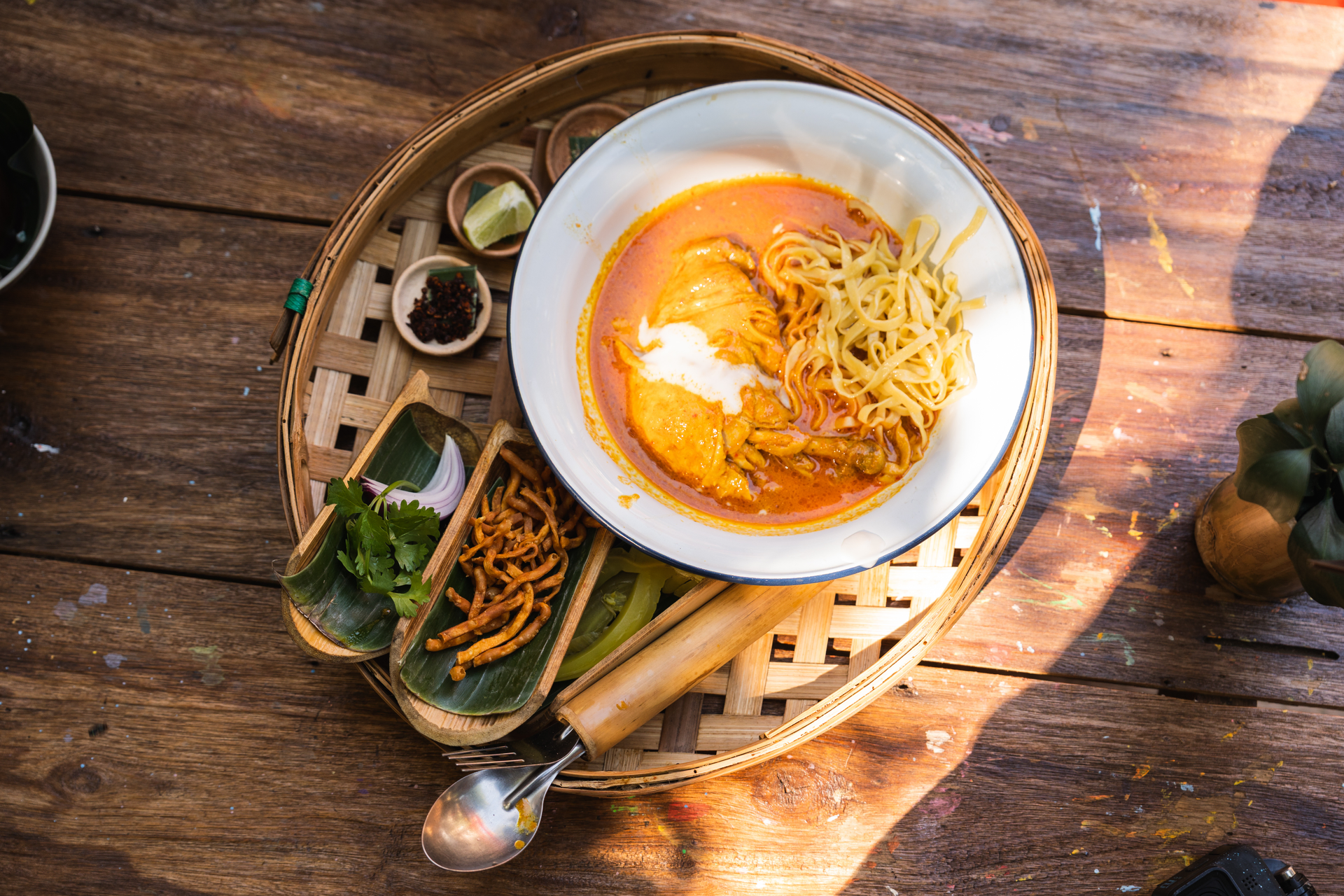 Overhead flat-lay of all ingredients for Thai Red Curry Noodle Soup with Jasmine Rice and Lime laid out on a kitchen surface.