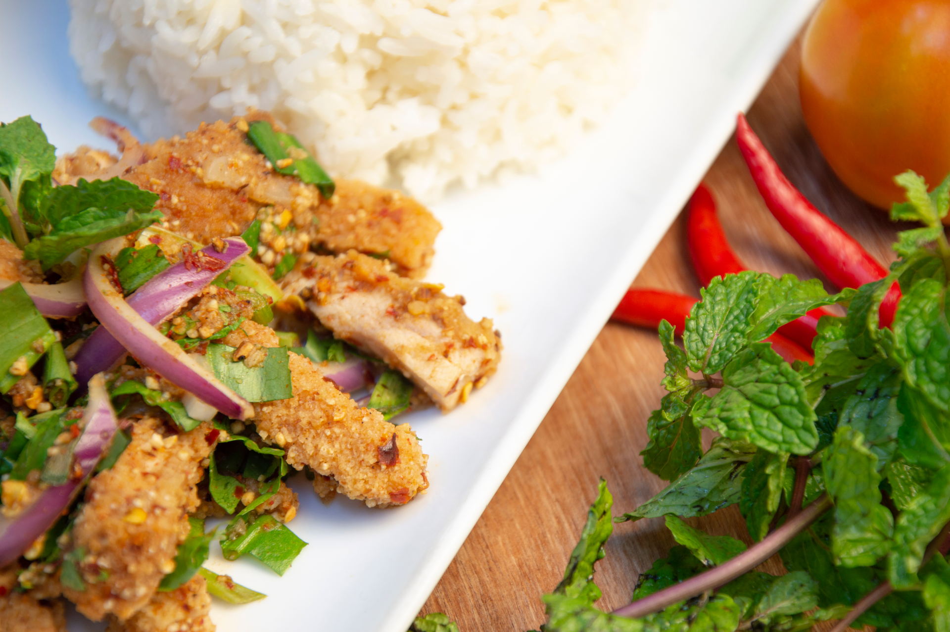 Overhead flat-lay of all ingredients for Thai Spicy Lemongrass Grilled Chicken with Coconut Rice laid out on a kitchen surface.