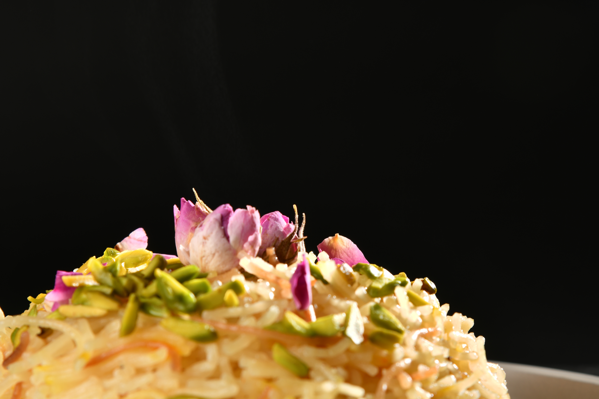 Overhead flat-lay of all ingredients for Toasted Persian Pistachio Rice with Rose Petals laid out on a kitchen surface.