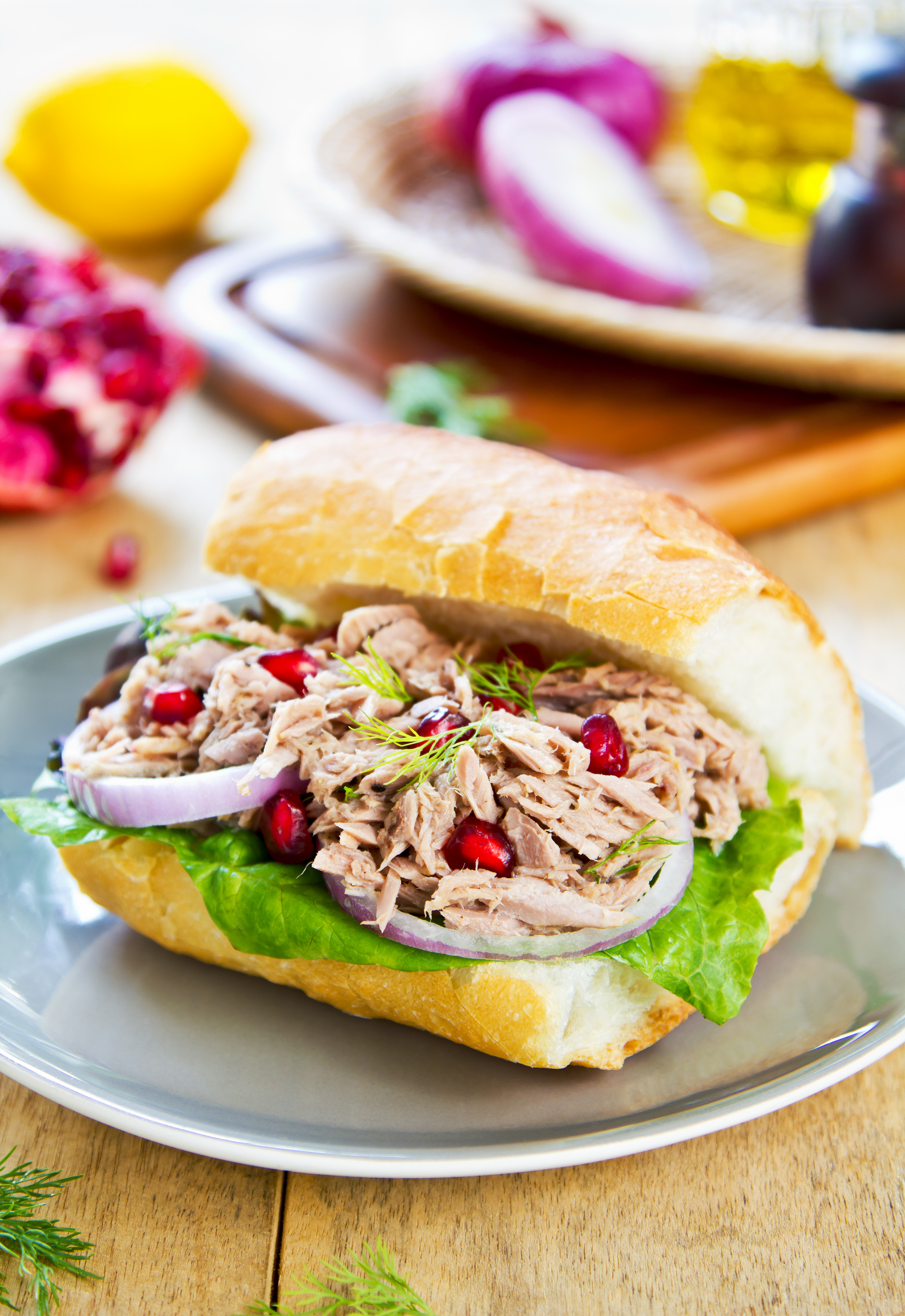 Overhead flat-lay of all ingredients for Tunisian Fricassé Sandwich with Spicy Harissa and Tuna Aioli laid out on a kitchen surface.
