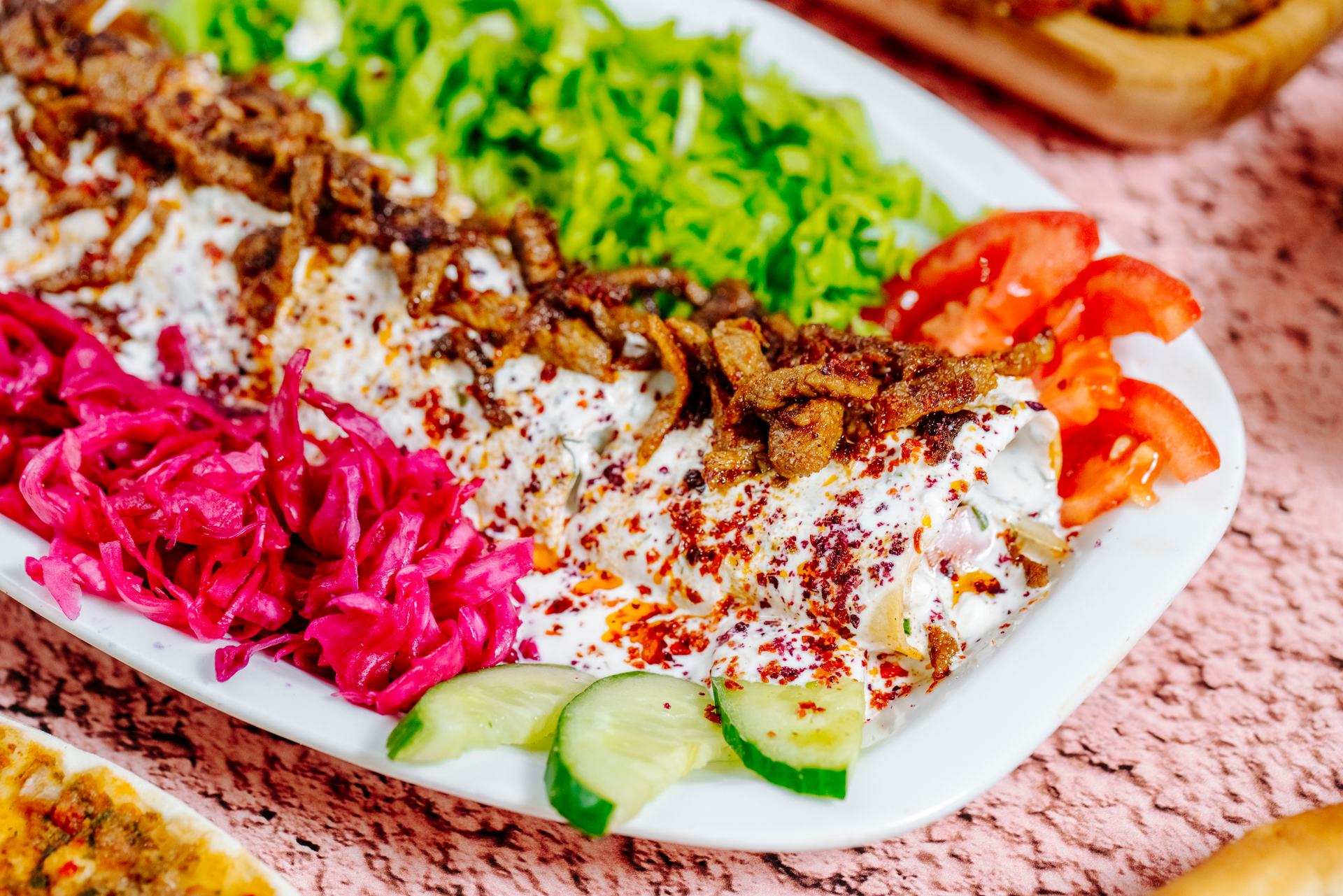 Overhead flat-lay of all ingredients for Turkish Kebab Wraps with Sumac Onions and Yogurt Sauce laid out on a kitchen surface.