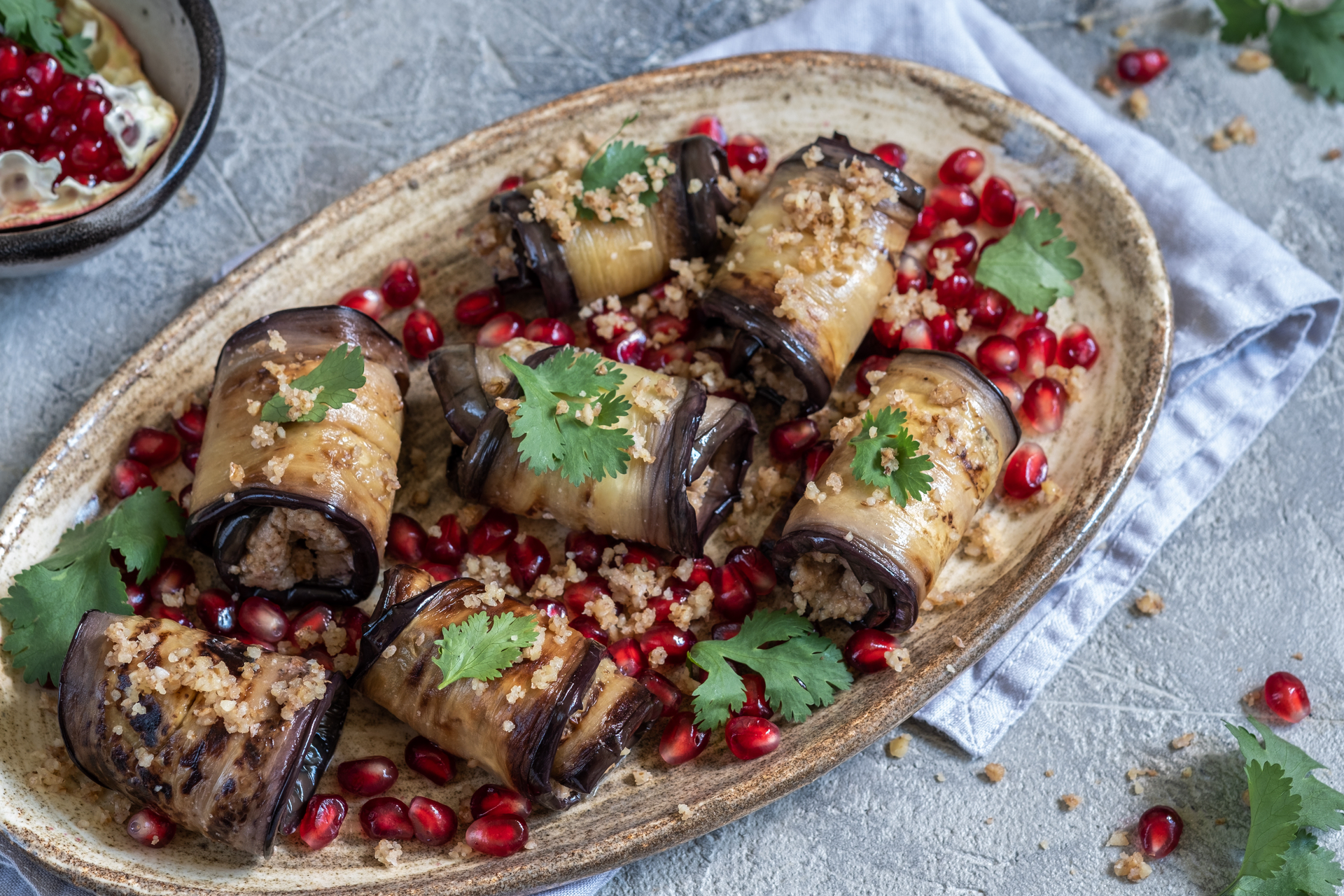 Overhead flat-lay of all ingredients for Turkish Stuffed Eggplant with Spiced Lamb and Pine Nuts laid out on a kitchen surface.