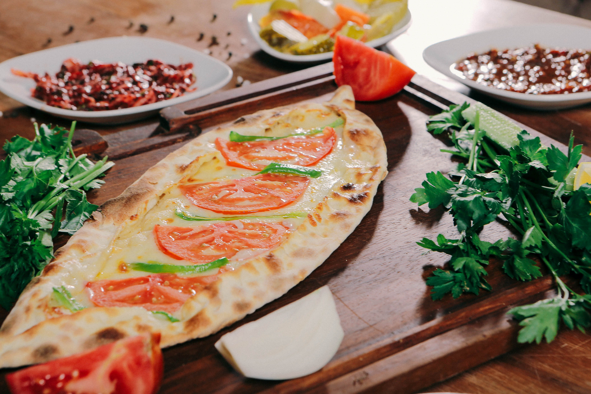 Overhead flat-lay of all ingredients for Turkish Zaatar-Spiced Pide with Halloumi and Olives laid out on a kitchen surface.