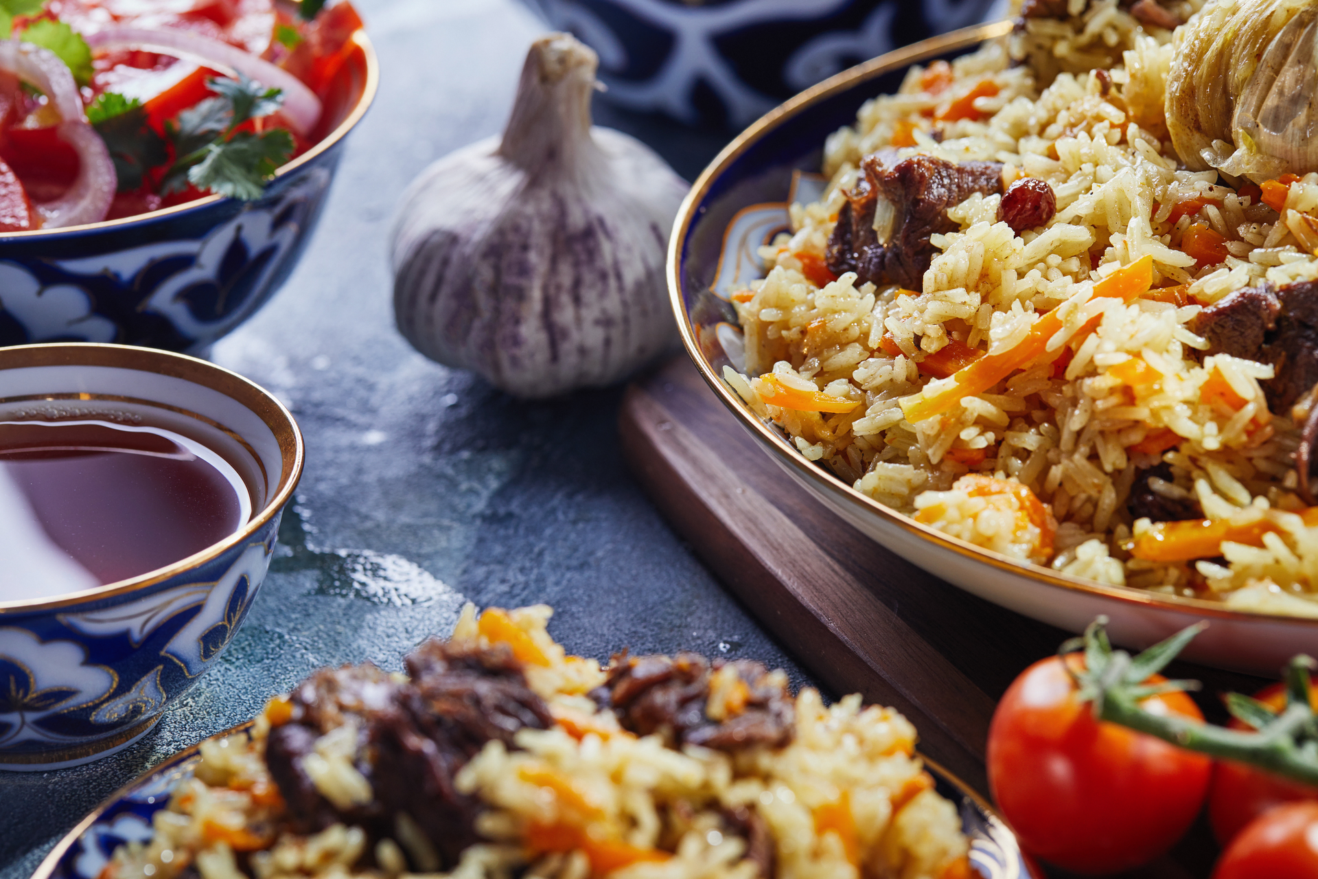 Overhead flat-lay of all ingredients for Uzbek Plov laid out on a kitchen surface.