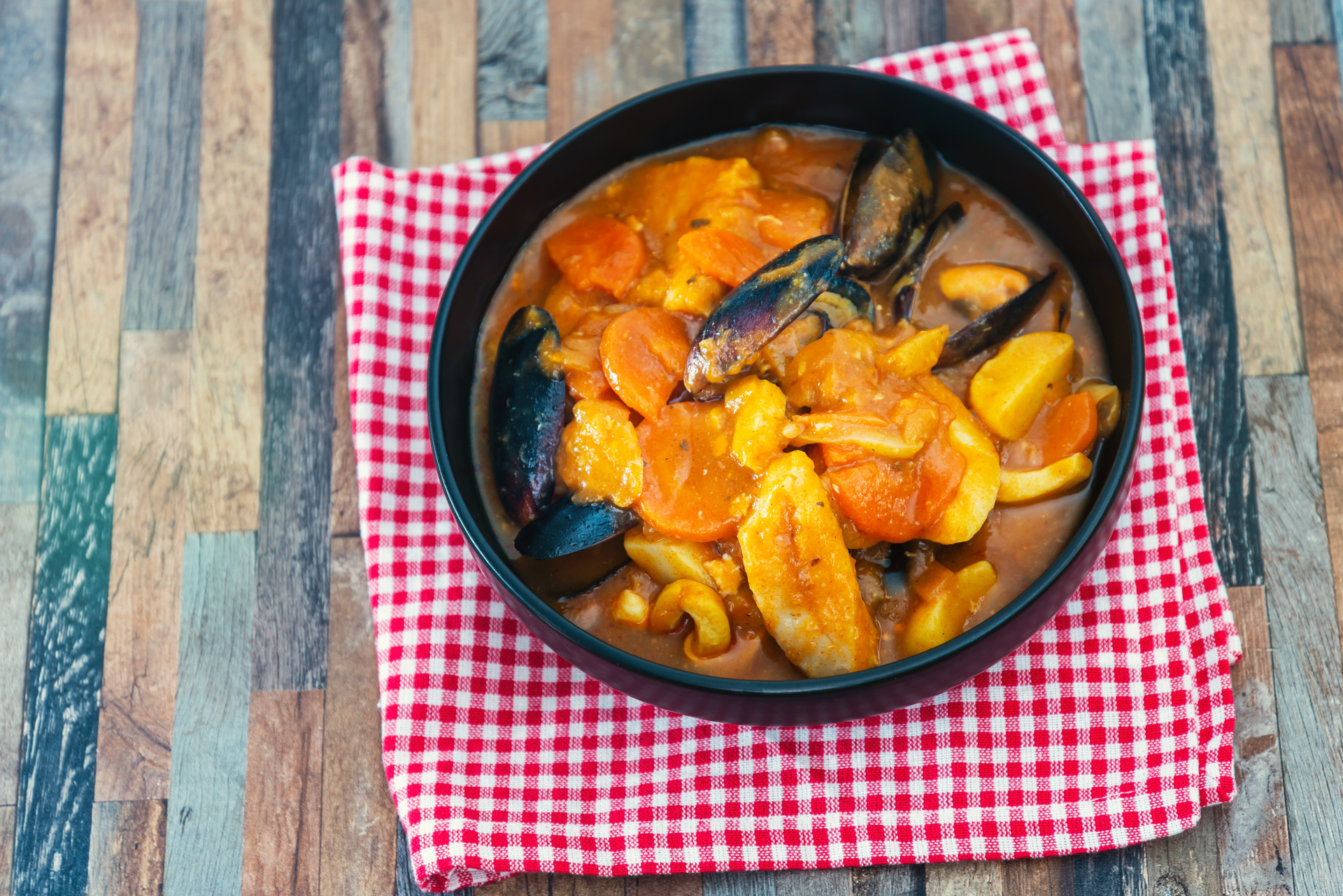 Overhead flat-lay of all ingredients for Velvety Colombian Cazuela de Mariscos with Coconut Milk laid out on a kitchen surface.