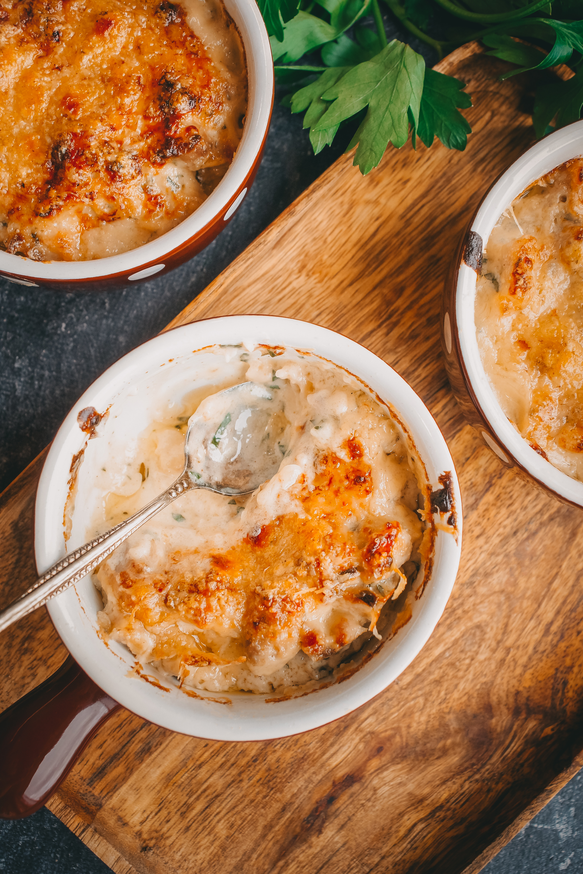 Overhead flat-lay of all ingredients for Velvety French Soupe à l'Oignon Gratinée with Gruyère laid out on a kitchen surface.