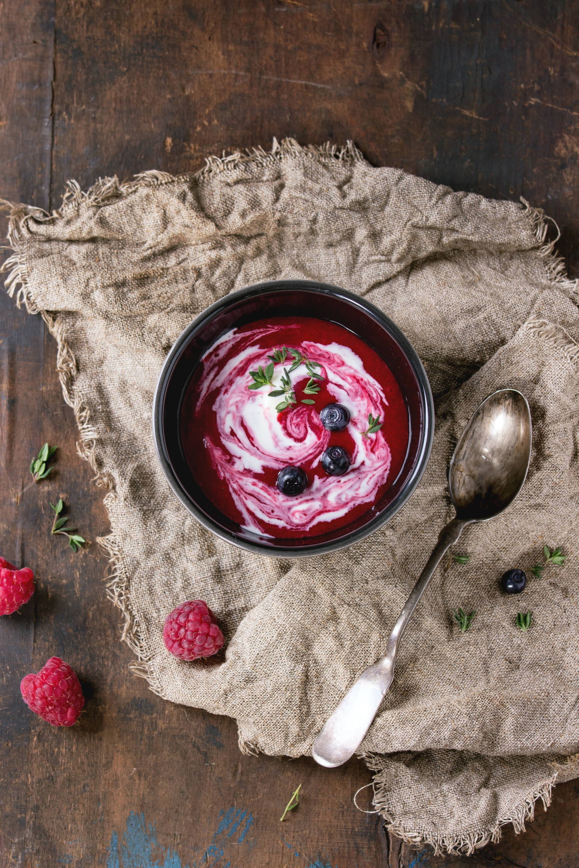 Overhead flat-lay of all ingredients for Velvety Italian Panna Cotta with Berry Coulis laid out on a kitchen surface.