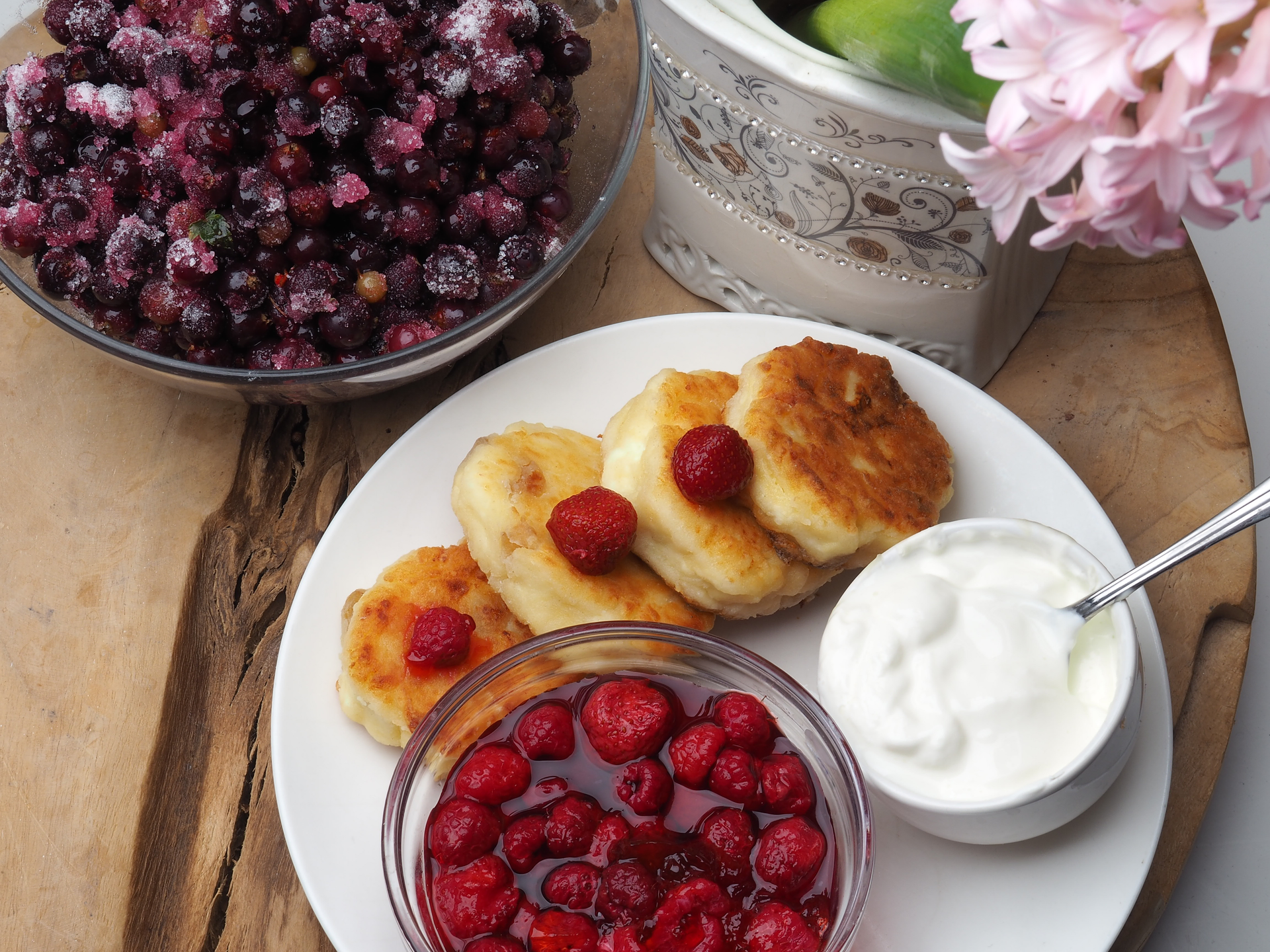 Overhead flat-lay of all ingredients for Velvety Russian Syrniki with Berry Compote and Sour Cream laid out on a kitchen surface.
