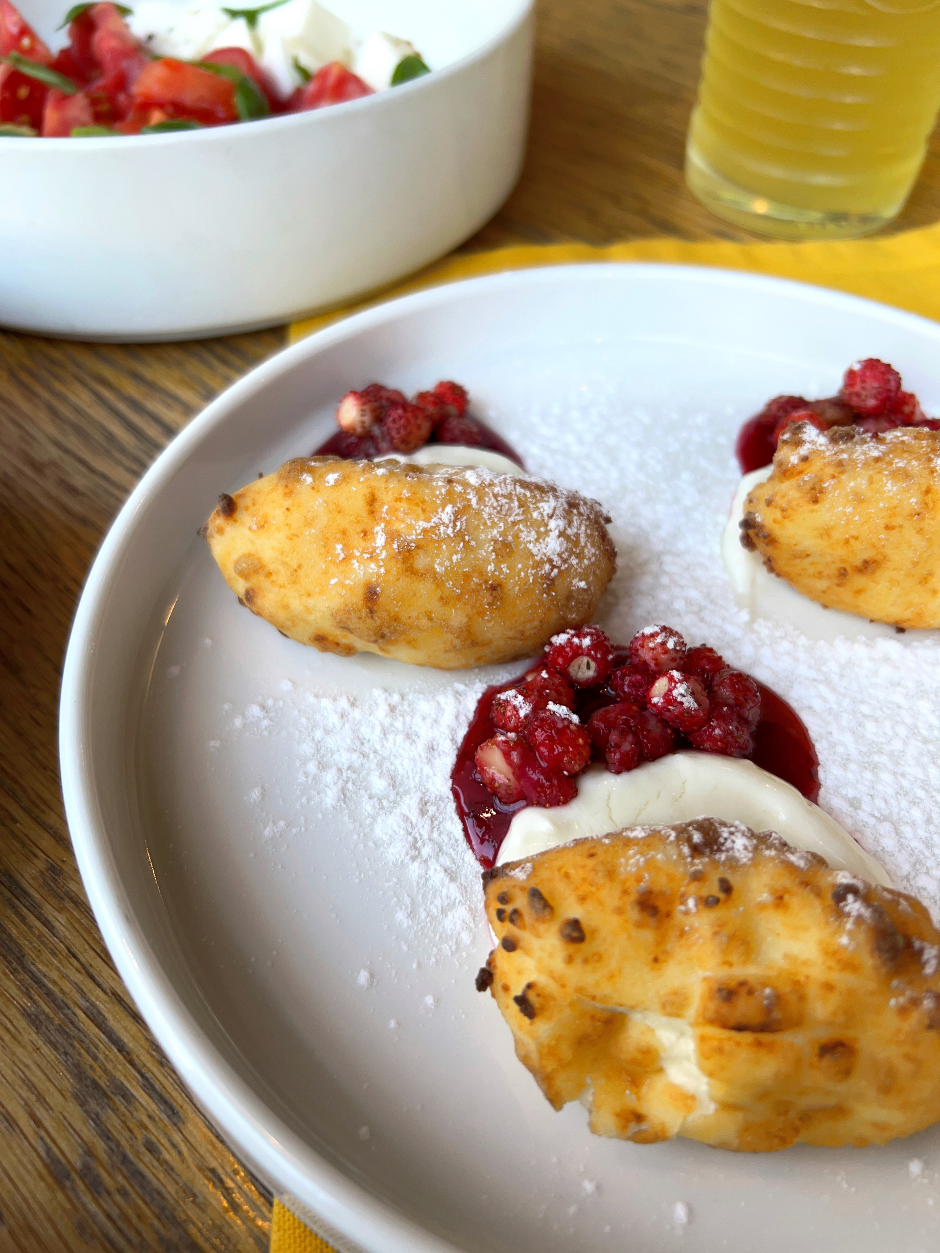 Velvety Russian Syrniki with Berry Compote and Sour Cream — Dessert served and photographed from above
