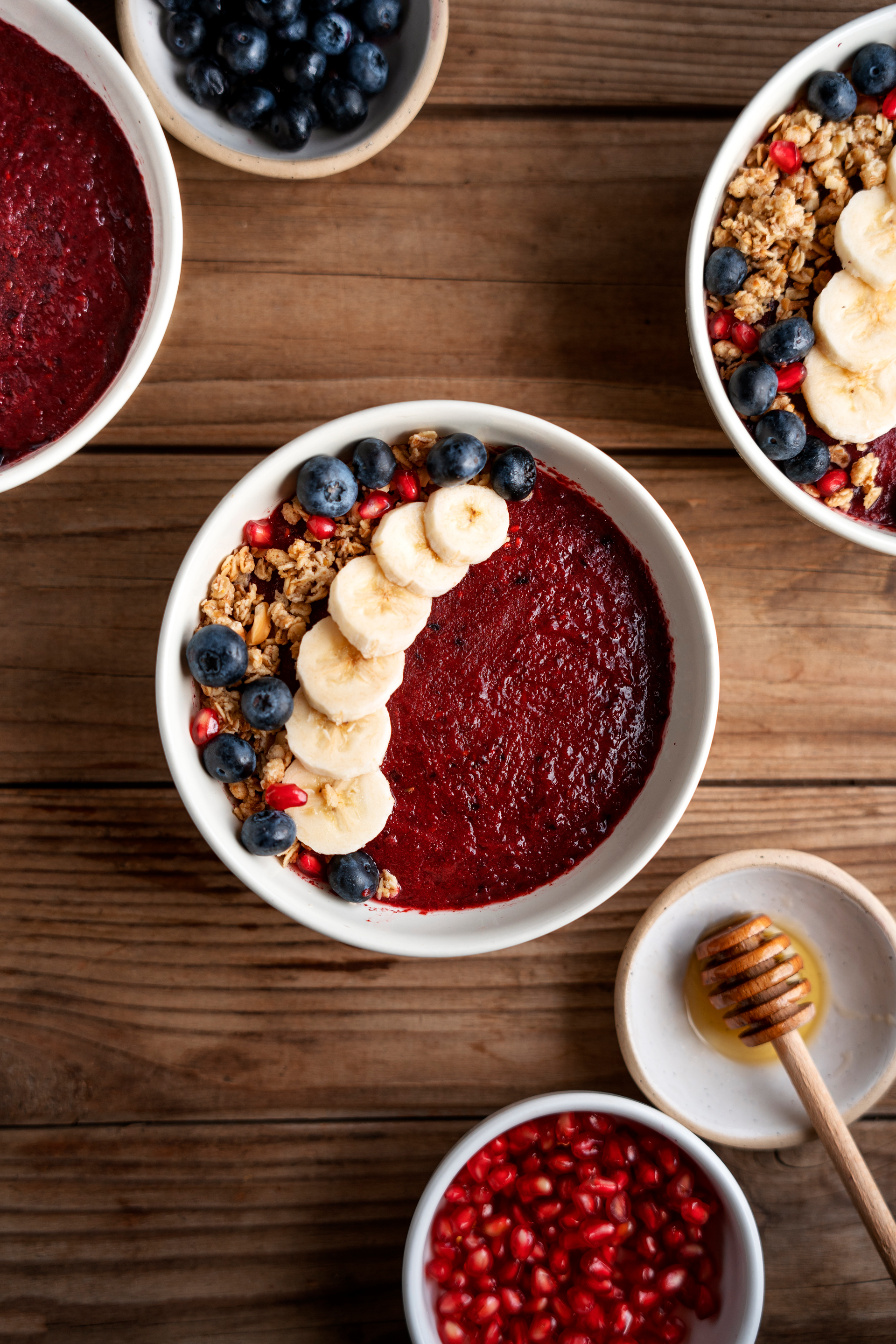 Overhead flat-lay of all ingredients for Vibrant Brazilian Açaí Smoothie Bowl with Tropical Fruits laid out on a kitchen surface.