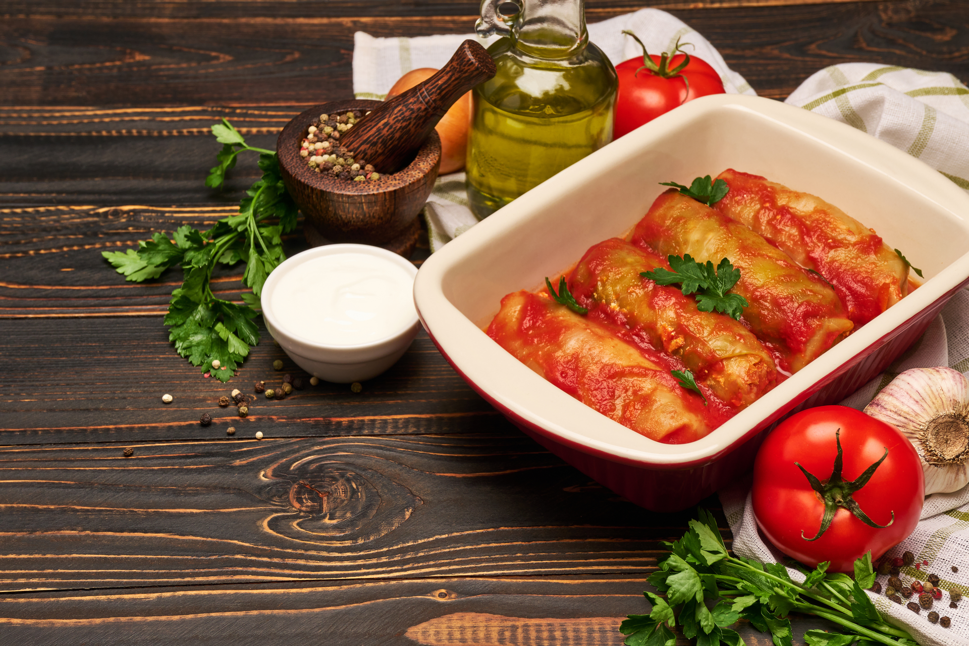 Overhead flat-lay of all ingredients for Warm Hungarian Töltött Káposzta with Tomato Sauce laid out on a kitchen surface.