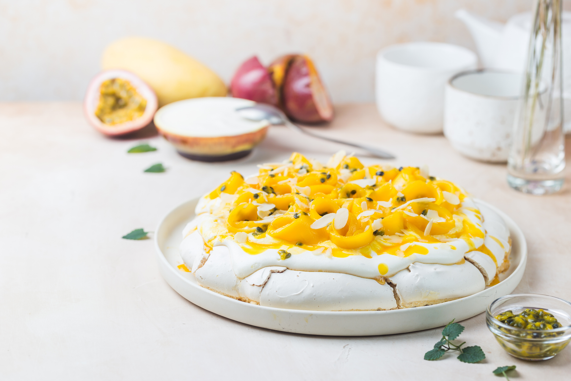 Overhead flat-lay of all ingredients for Zesty Australian Pavlova with Passionfruit and Kiwi laid out on a kitchen surface.
