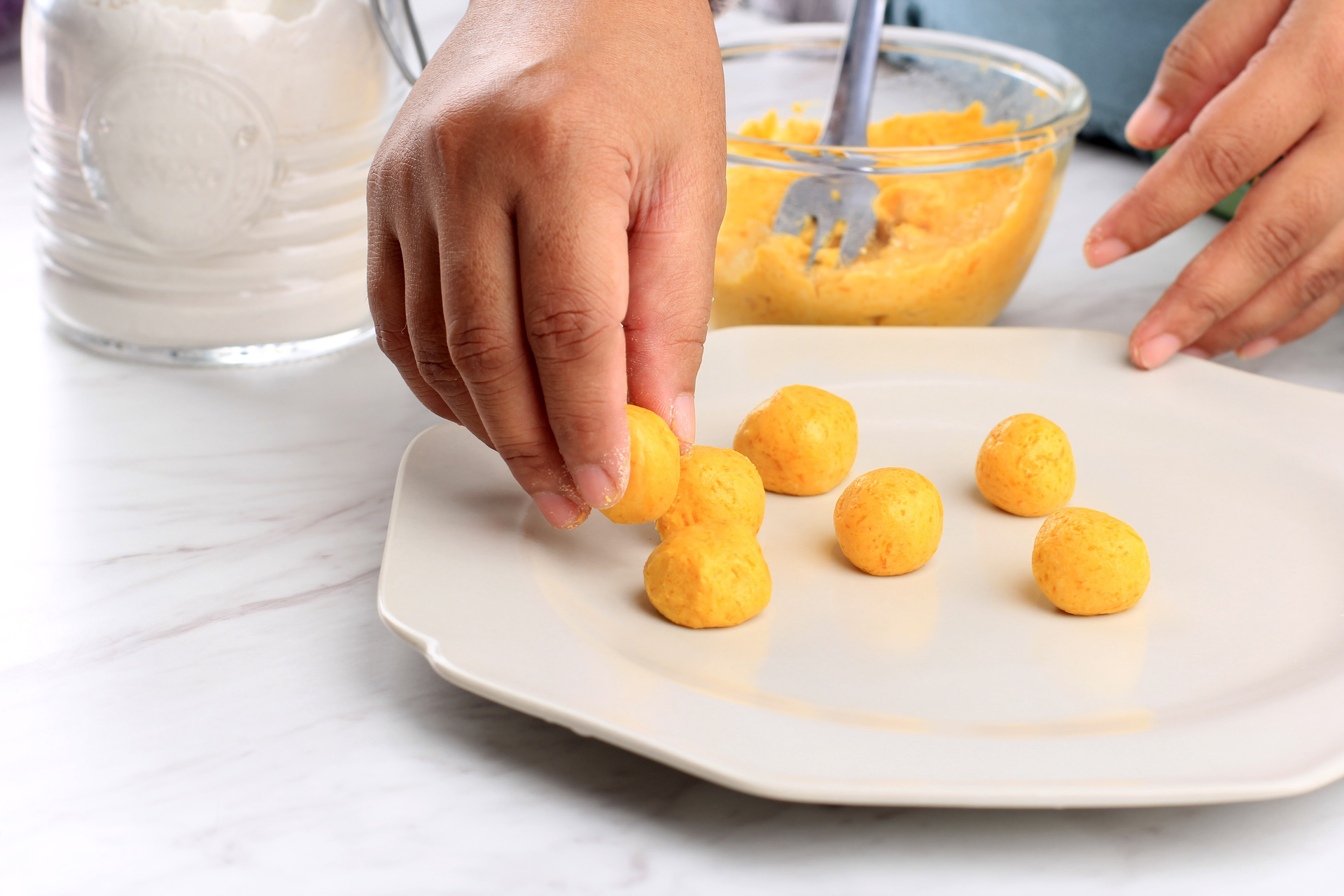Overhead flat-lay of all ingredients for Zesty Brazilian Bacalhau Balls with Passionfruit Dip laid out on a kitchen surface.