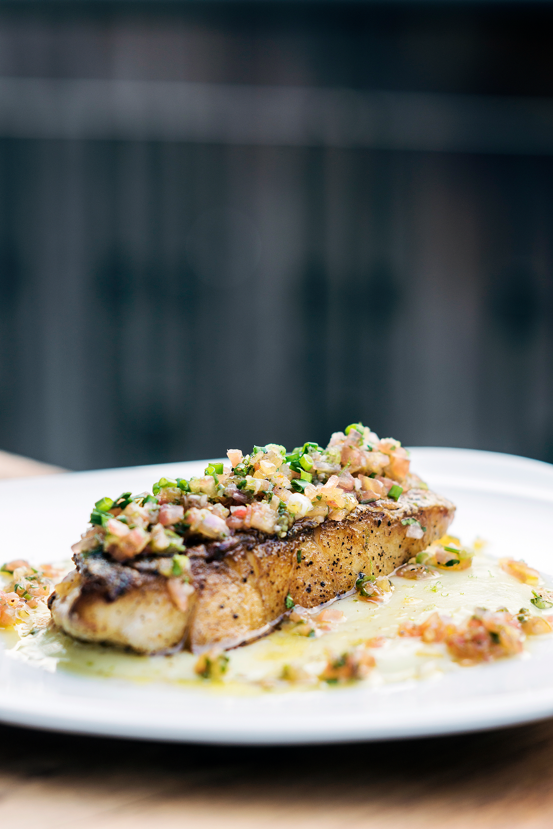 Overhead flat-lay of all ingredients for Zesty Chilean Sea Bass with Capers and Artichokes laid out on a kitchen surface.