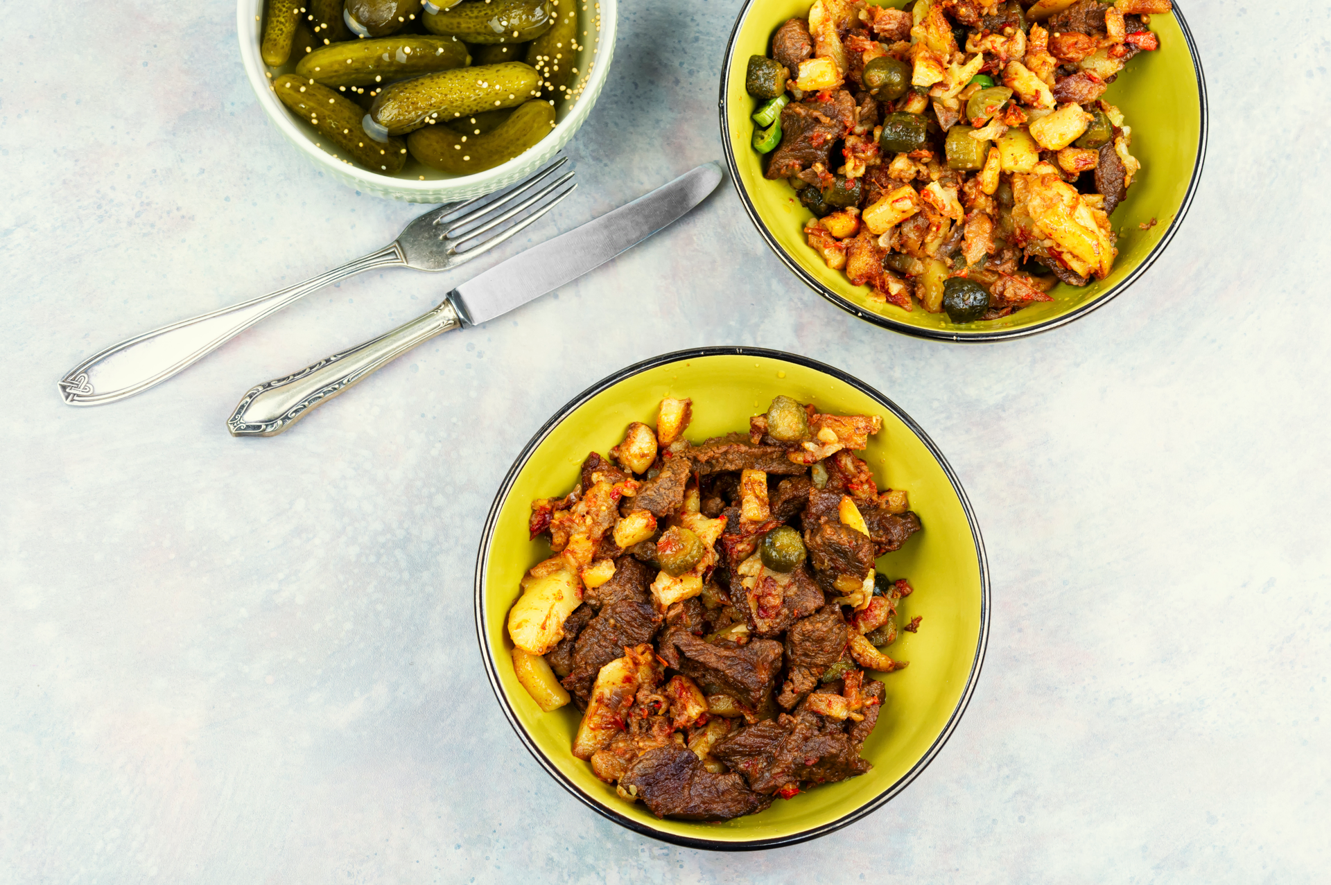 Overhead flat-lay of all ingredients for Zesty Cuban Picadillo with Green Olives and Raisins laid out on a kitchen surface.