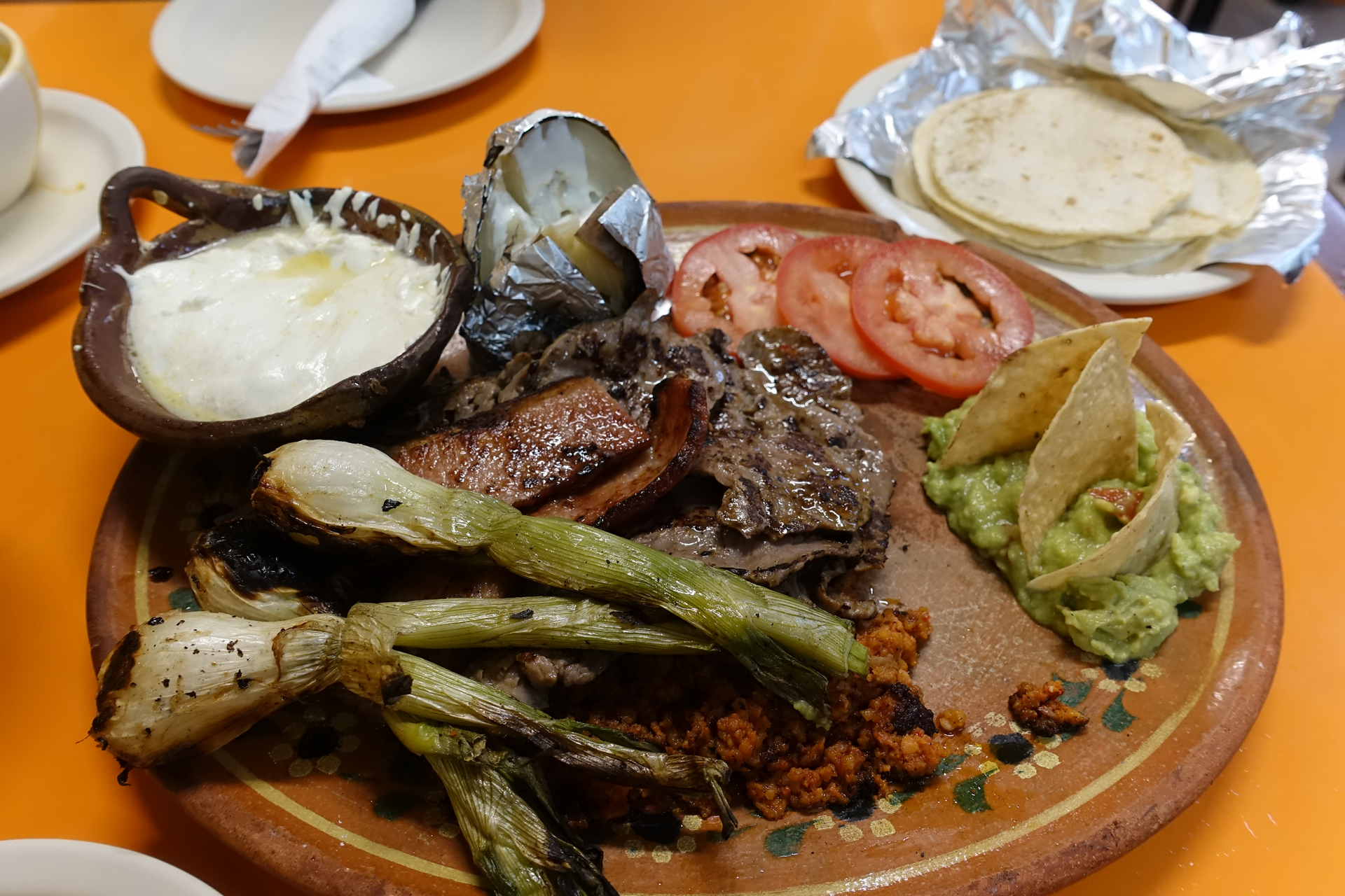 Overhead flat-lay of all ingredients for Zesty Ecuadorian Cuy Asado with Chimichurri laid out on a kitchen surface.