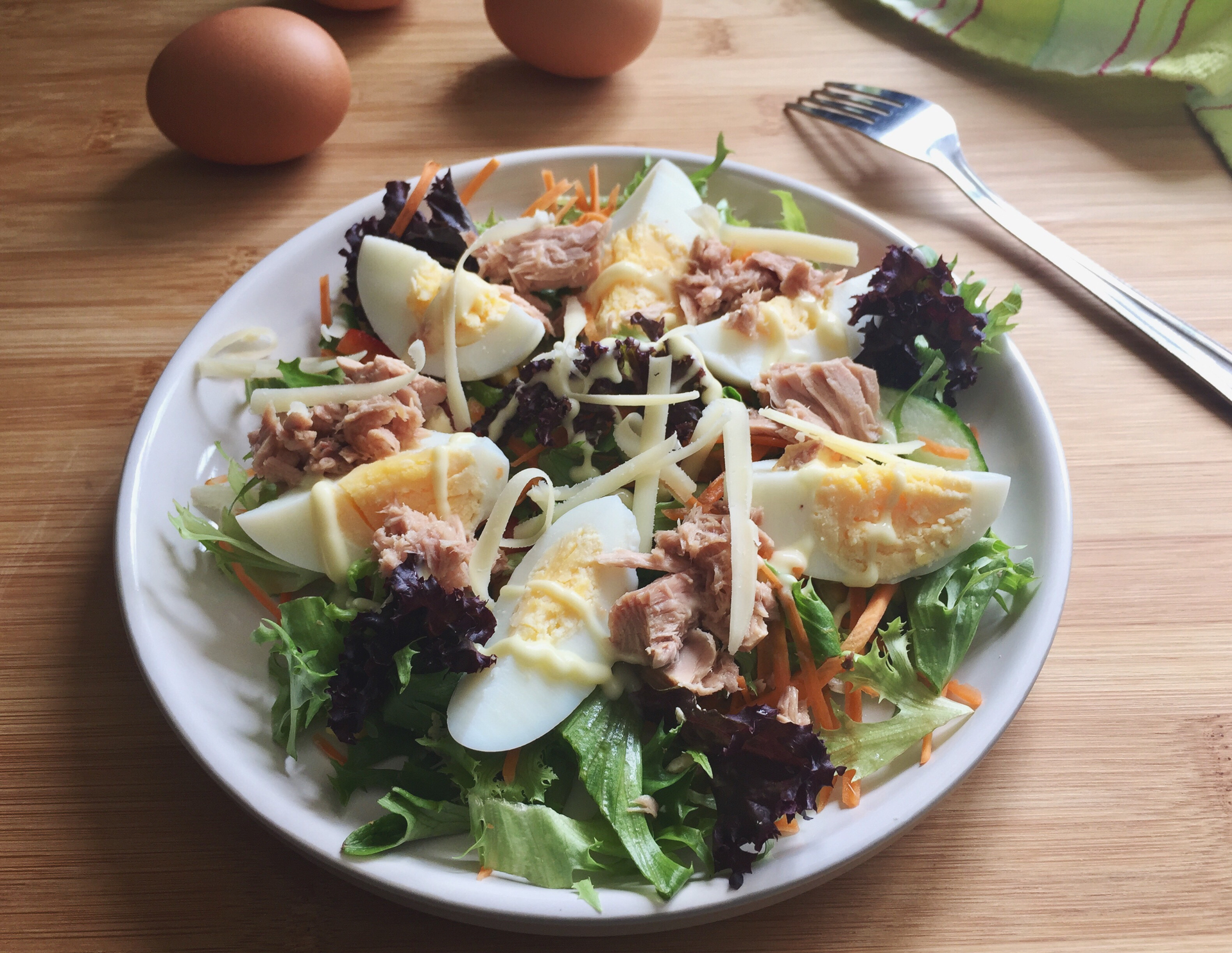 Overhead flat-lay of all ingredients for Zesty French Frisée Salad with Lardons and Poached Egg laid out on a kitchen surface.