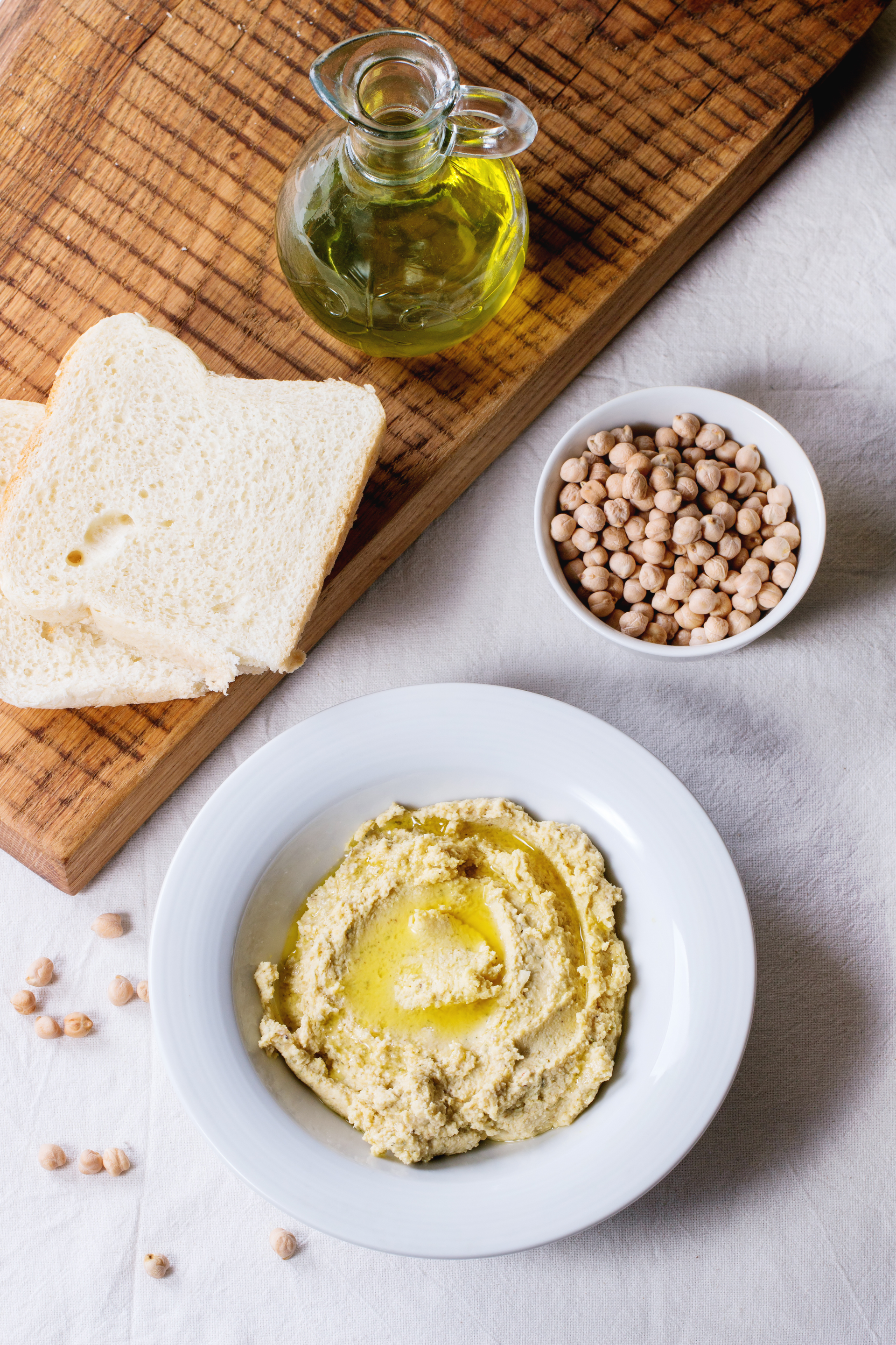 Overhead flat-lay of all ingredients for Zesty Greek Fava Bean Dip with Lemon Zest laid out on a kitchen surface.