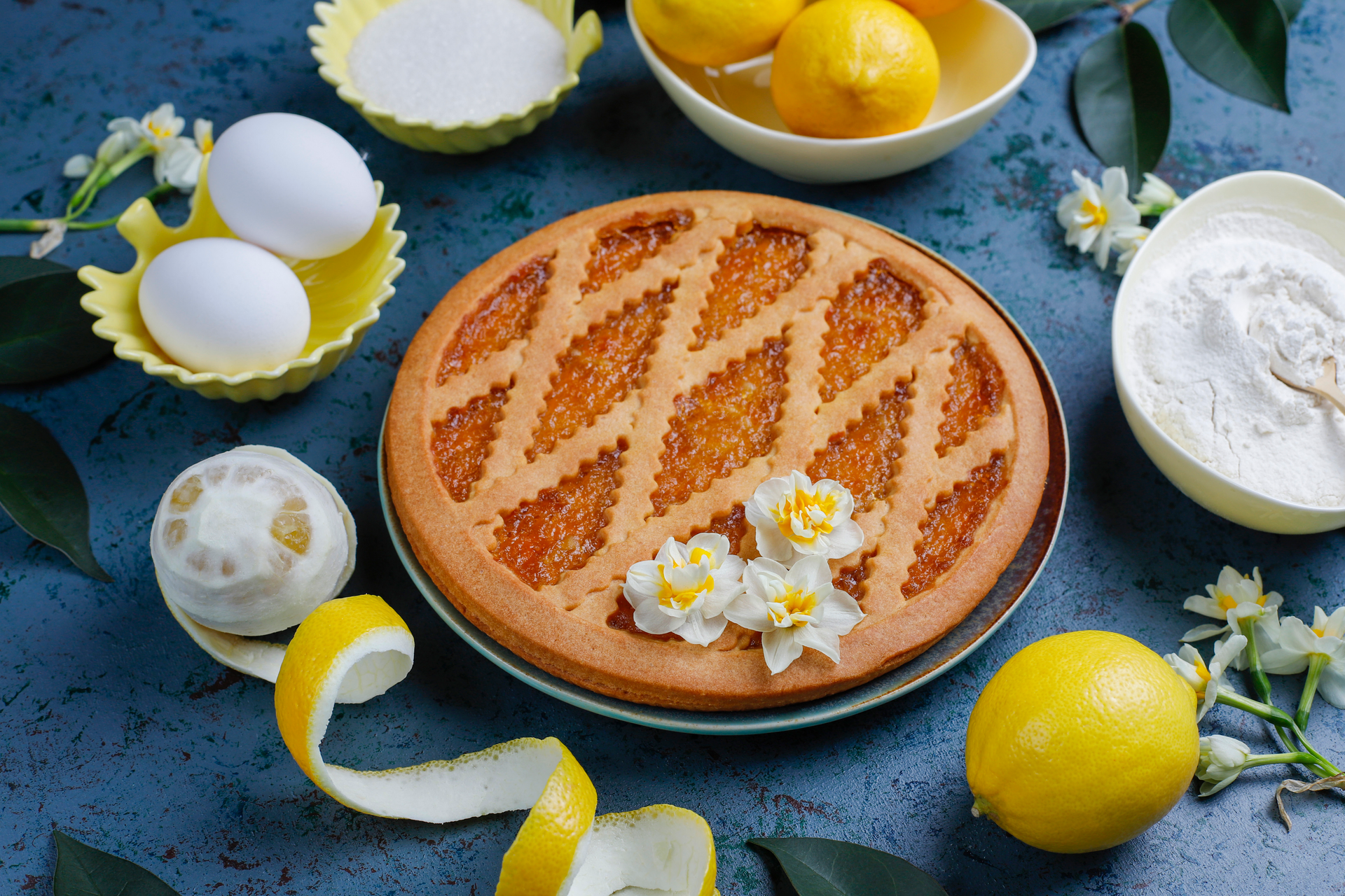 Overhead flat-lay of all ingredients for Zesty Greek Lemon Buttermilk Pie with Almond Biscuit Crust laid out on a kitchen surface.