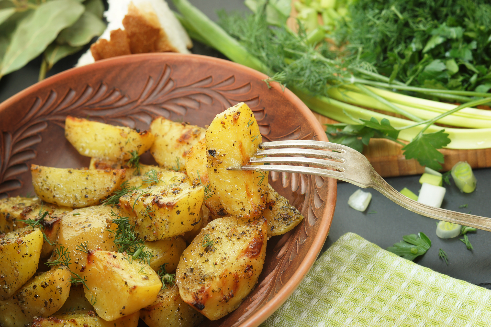 Overhead flat-lay of all ingredients for Greek lemon potatoes with garlic and oregano laid out on a kitchen surface.