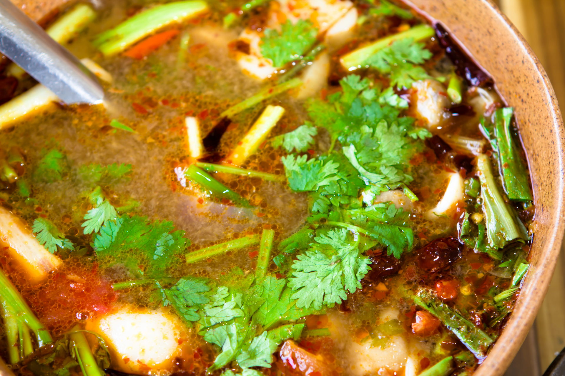 Overhead flat-lay of all ingredients for Zesty Haitian Bouillon with Fresh Vegetables and Spices laid out on a kitchen surface.