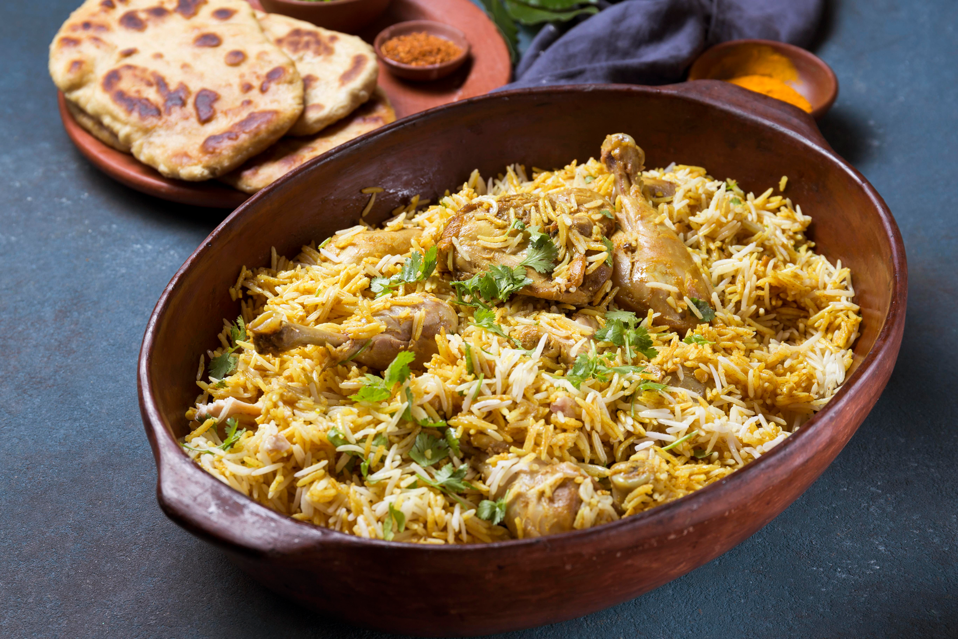 Overhead flat-lay of all ingredients for Zesty Indian Dhansak Biryani laid out on a kitchen surface.