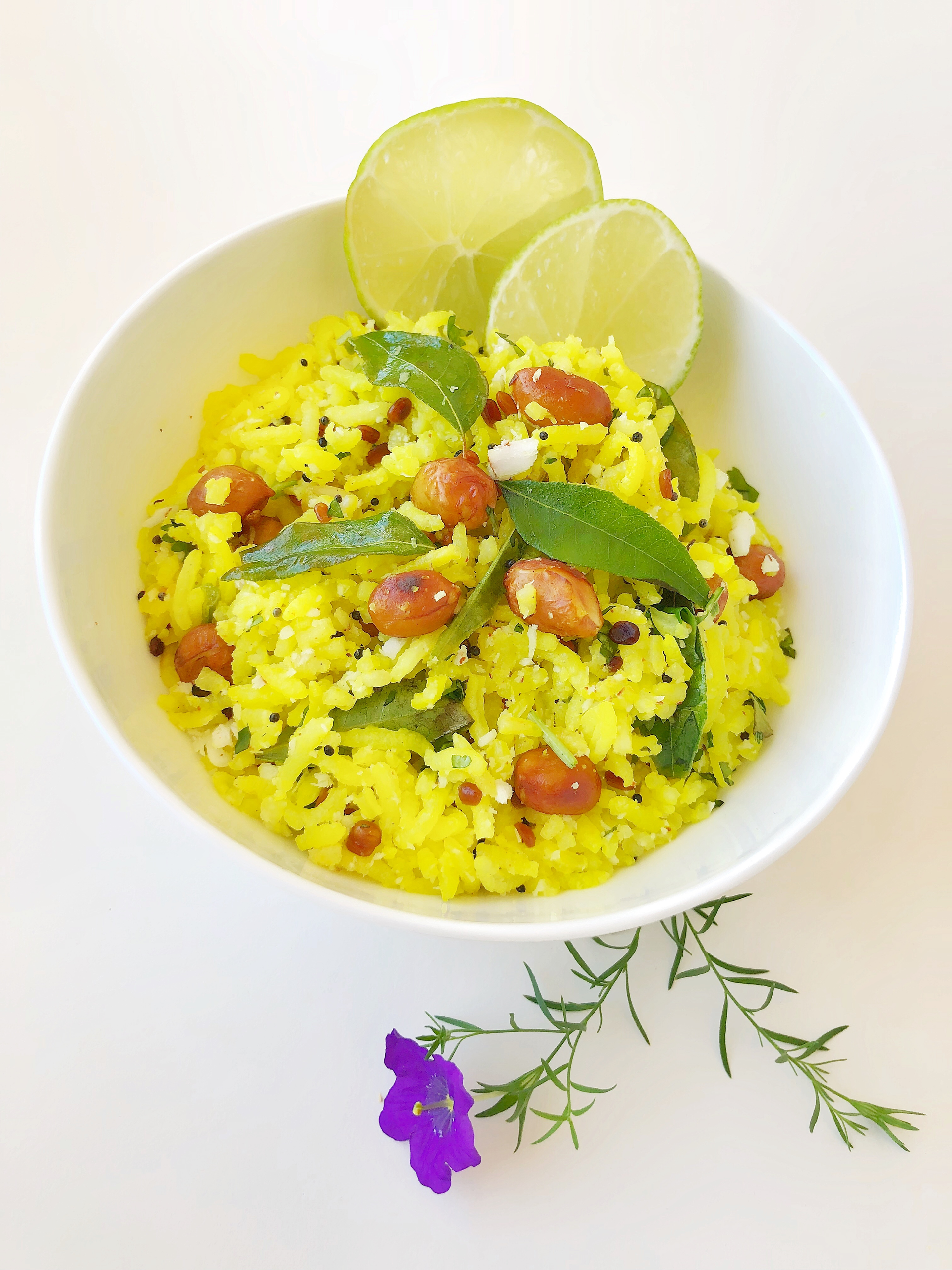 Overhead flat-lay of all ingredients for Zesty Indian Lemon Rice with Cashews and Curry Leaves laid out on a kitchen surface.