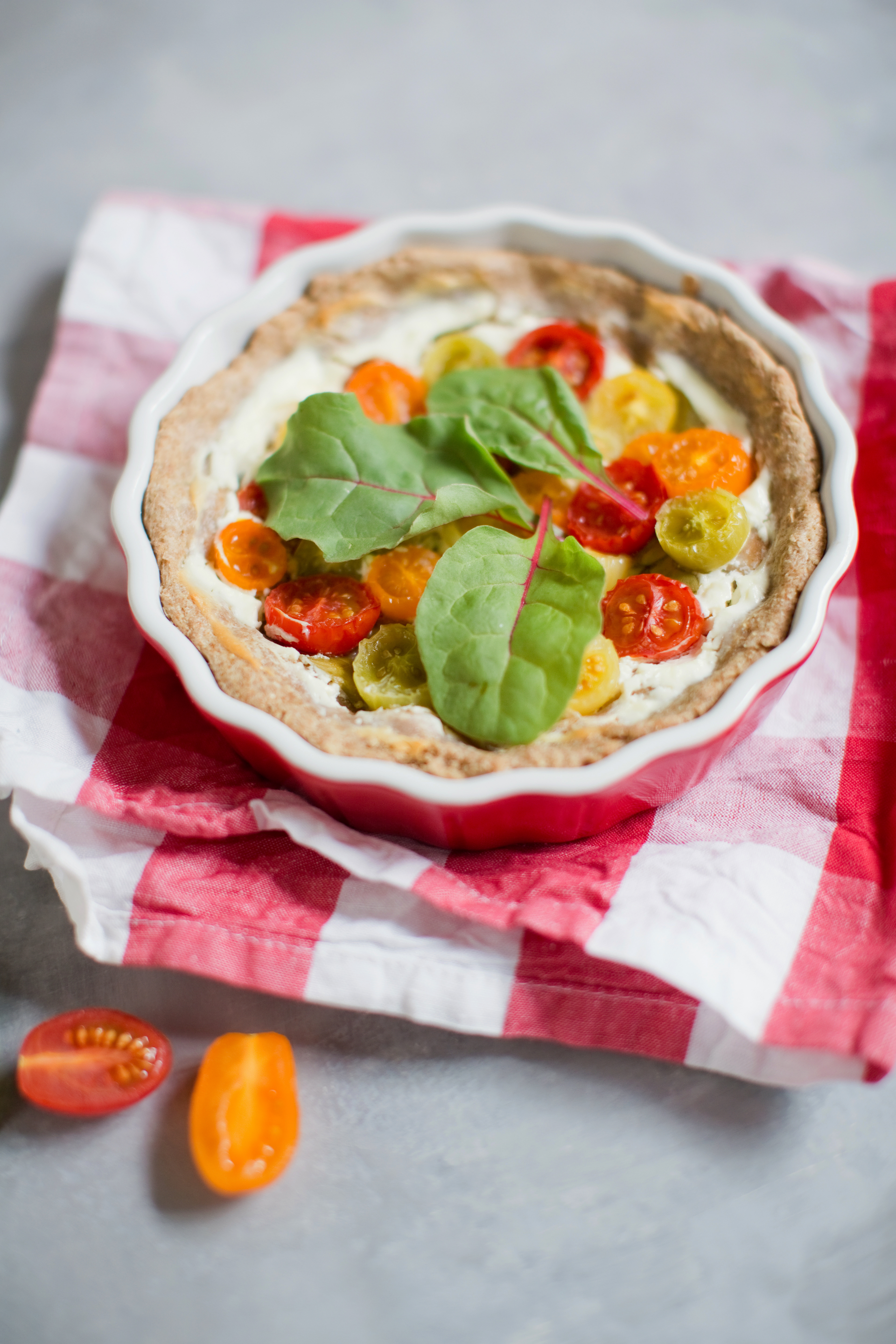 Overhead flat-lay of all ingredients for Zesty Italian Burrata and Heirloom Tomato Tart with Basil Pesto laid out on a kitchen surface.