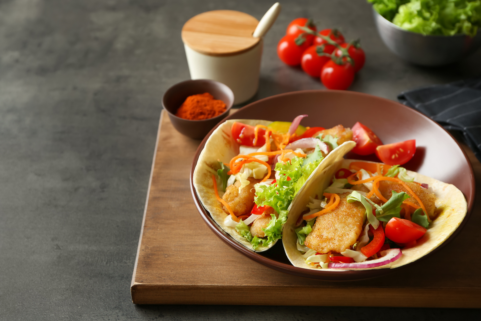 Overhead flat-lay of all ingredients for Zesty Korean Gochujang Tofu Tacos with Kimchi Slaw laid out on a kitchen surface.