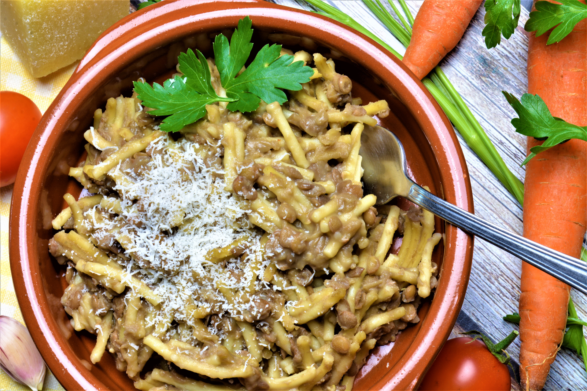 Overhead flat-lay of all ingredients for Zesty Sicilian Pasta con le Sarde with Fennel and Pine Nuts laid out on a kitchen surface.