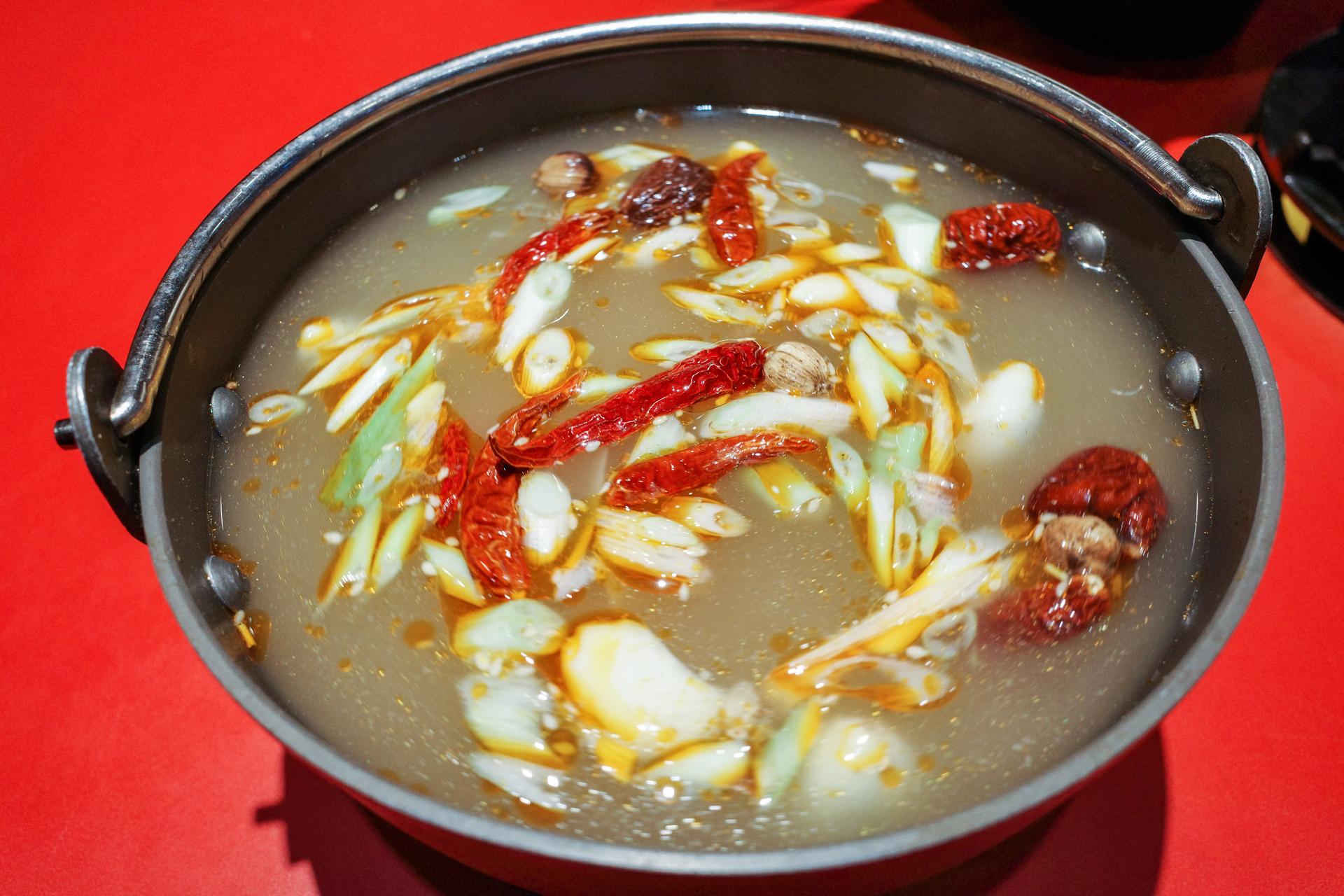 Overhead flat-lay of all ingredients for Zesty Szechuan Crayfish Hotpot with Ginger-Chili Broth laid out on a kitchen surface.