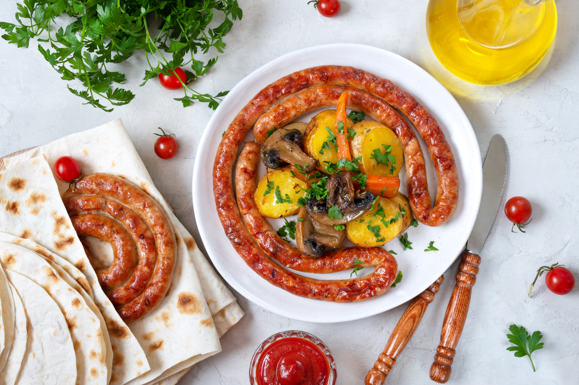 Overhead flat-lay of all ingredients for Zesty Tunisian Ojja with Spicy Merguez Sausages laid out on a kitchen surface.