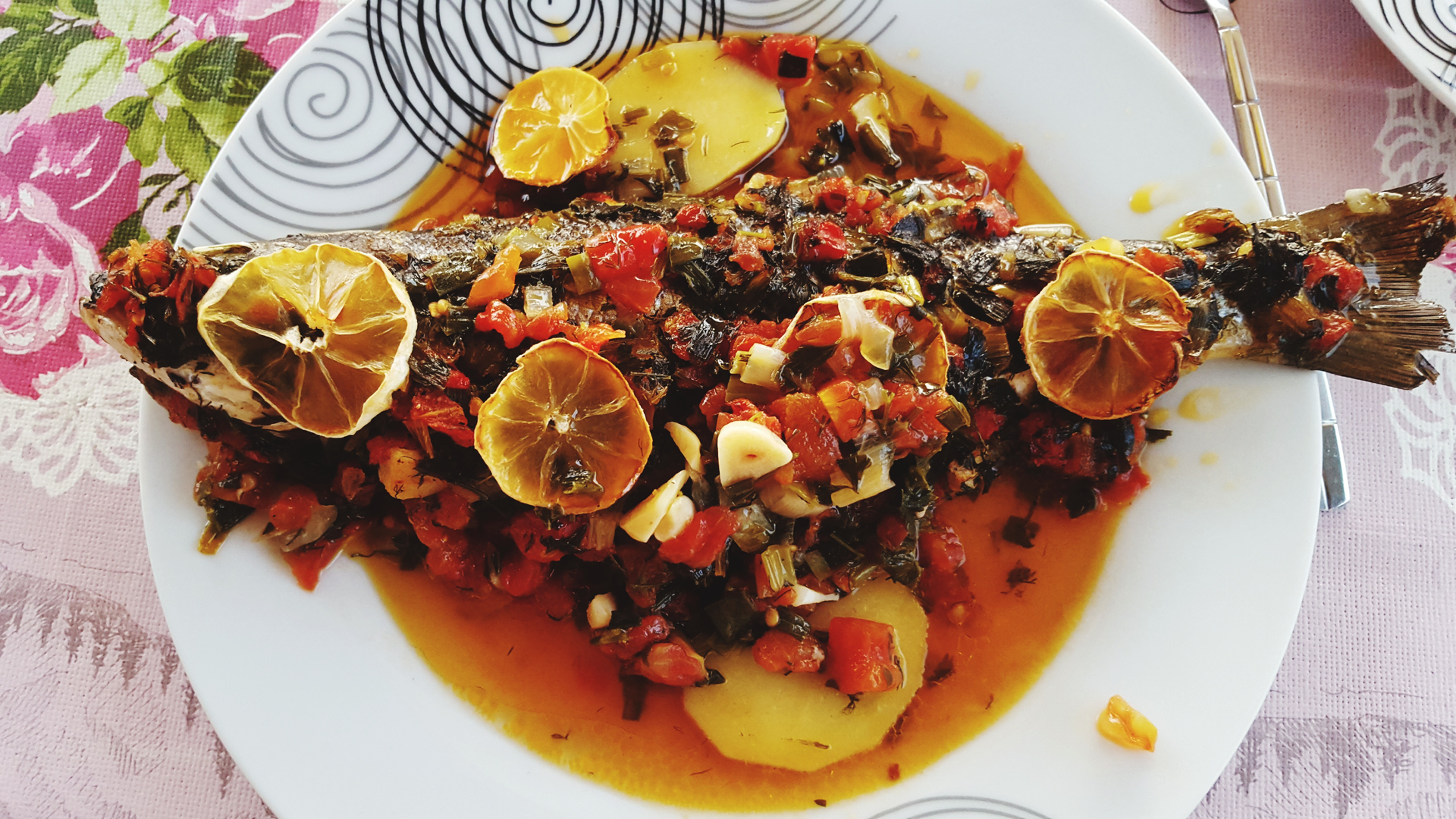 Overhead flat-lay of all ingredients for Zesty Zambian Kapenta with Roasted Peppers laid out on a kitchen surface.